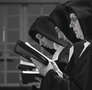 Sisters praying from prayer books